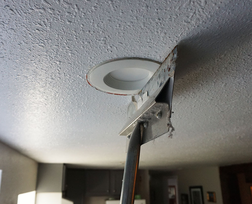 tile scraper used to hold can light in place while acoustical caulk dried