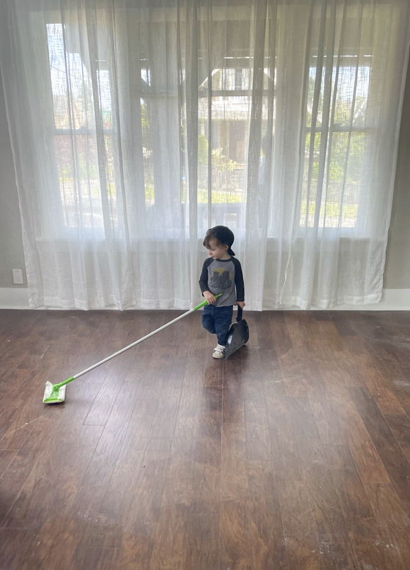 toddler sweeping a floor